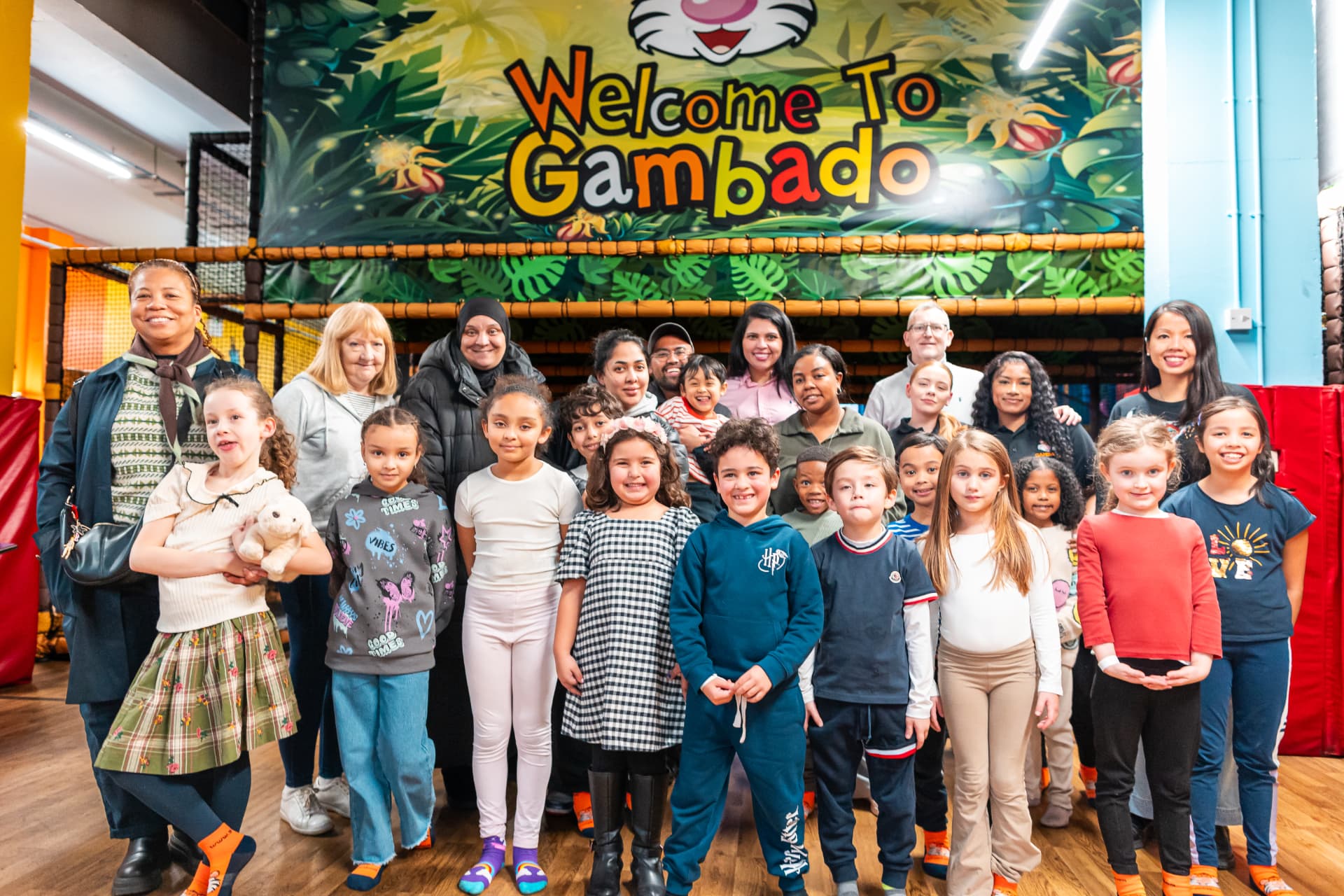 Group of children under the Welcome to Gambado sign